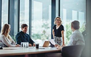 Leadership und Team – © Jacob Lund / Shutterstock 4 Leute am Konferenztisch bei einem Meeting.
