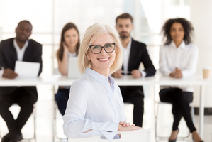 © fizkes / Shutterstock In einem Konferenzraum sitzen die Referentin und ihre 4 Zuhörer.