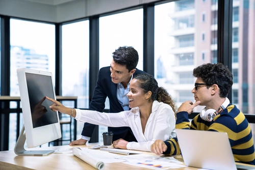 © Basicdog / Adobe Stock 3 Personen am Schreibtisch vor dem Computer