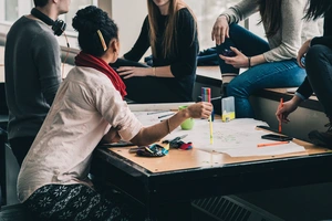 © StockSnap / Pixabay 5 junge Leute in legerer Kleidung besprechen sich an einem Schreibtisch.